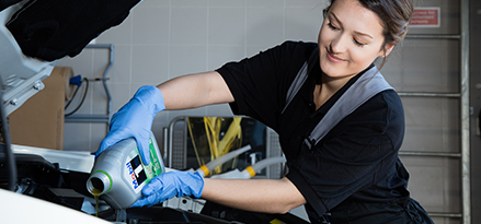 Femme versant de l'huile dans le moteur