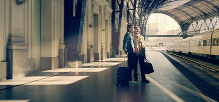 Deux personnes debout dans une gare.
